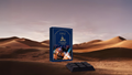 Chocolate bar form with packaging labeled 'Uraz Bakhoor Amer' in a desert setting