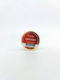 Small container of 'Dreams' perfume cream on a white background