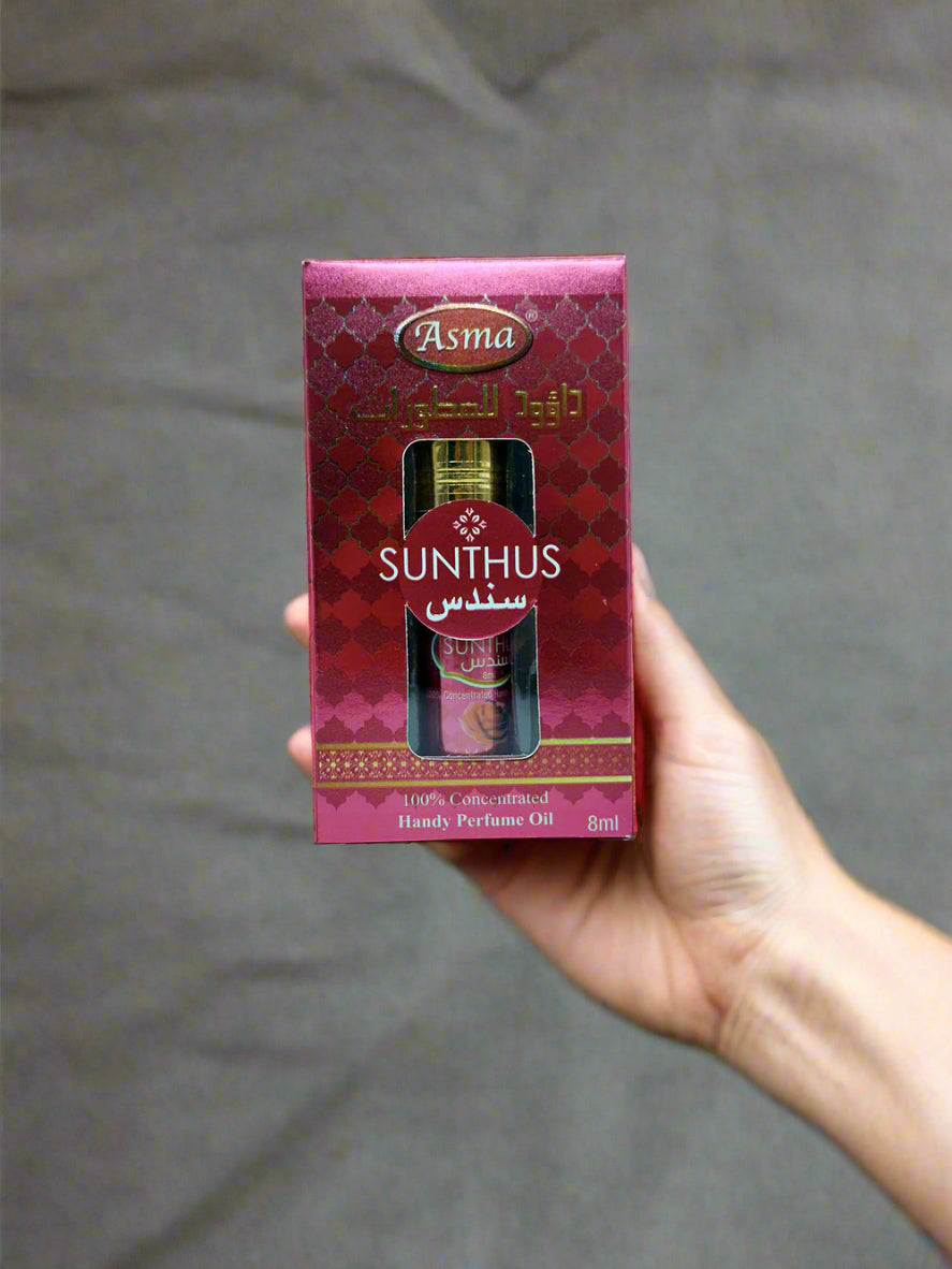 Box of Sunthus perfume oil with Asma branding on a light blue background